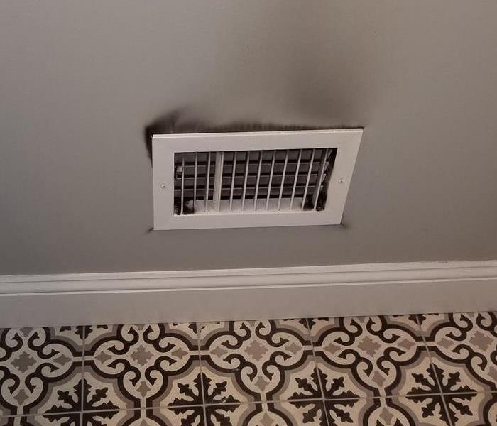 Heating vent with soot from furnace.