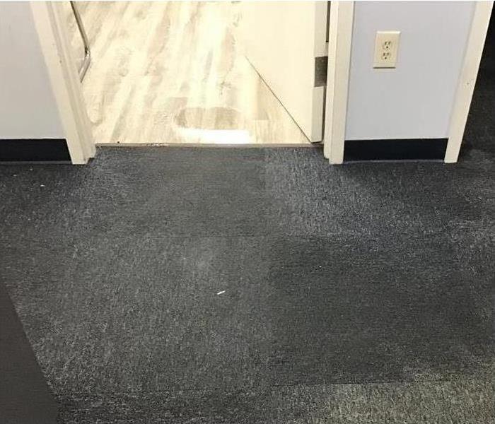 Wet floor and carpet from a storm in office.