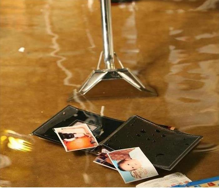 Flooding water with wallet and photos and a SERVPRO shop vacuum. 